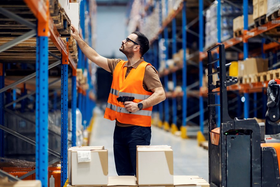 A warehouse employee organizing inventory to meet customer demand.