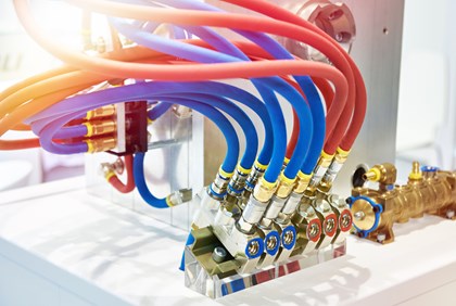 Hydraulic hose and fittings connected to a hydraulic machine.